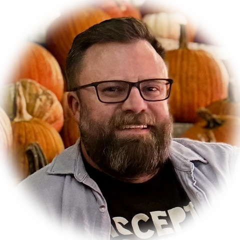 Colin Weir, smiling, with pumpkins behind him.